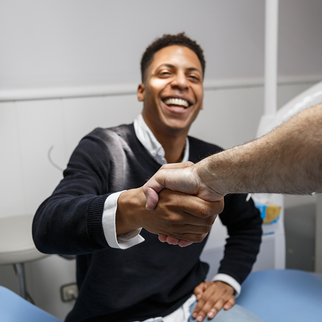 Male dental patient shaking hands with a dentist