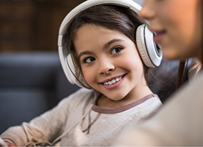 Girl wearing headphones and smiling at someone