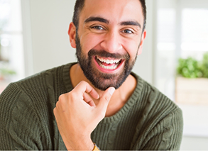 Bearded man in kitchen sitting and smiling