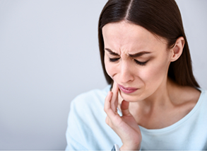 Close-up of woman with tooth pain rubbing jaw