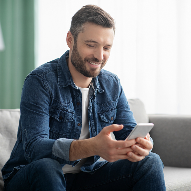 Man sitting on couch looking at his phone